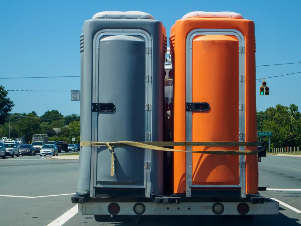 Porta potty rental on a flatbed truck, ready for delivery